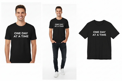 Black t-shirt with 'ONE DAY AT A TIME' text worn by a person on a white background