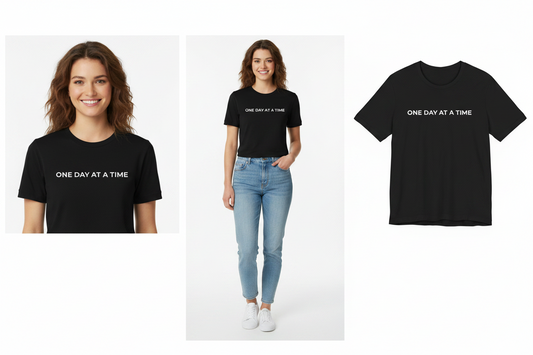 Black t-shirt with 'ONE DAY AT A TIME' text worn by a model on a white background